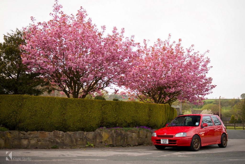 Toyota Starlet EP91 next to blossoms