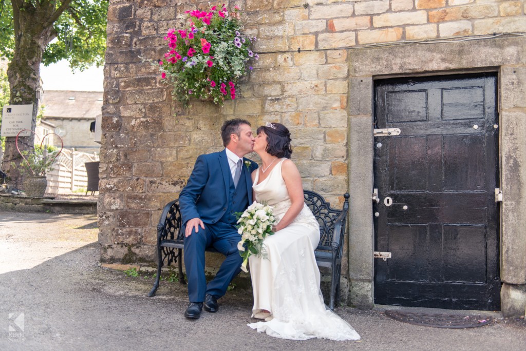 Bride and Groom enjoying a kiss on a bench