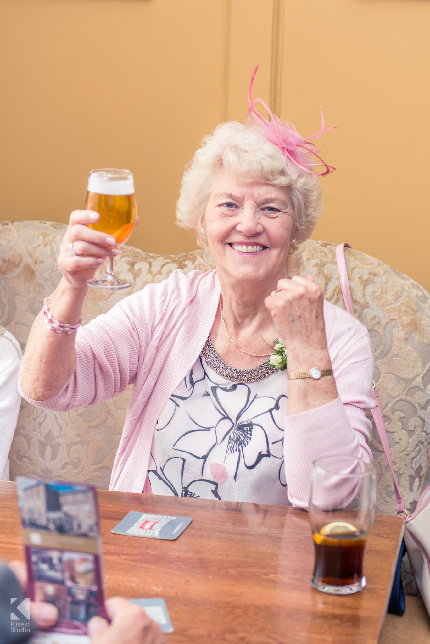 Brides mother raising her beer glass in joy